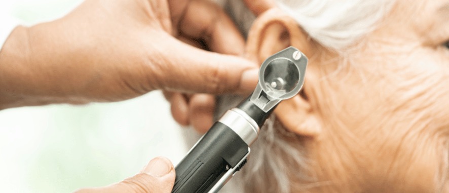 Hearing care professional examining a hearing aid to determine whether it needs repair or replacement at Aanvii Hearing